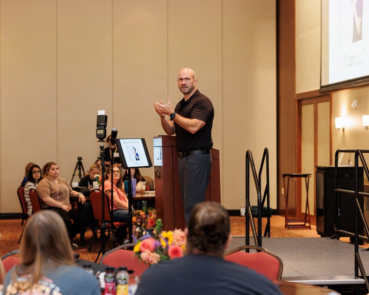 Keynote speaker Jim Harris speaks to early child care professionals at a stage.