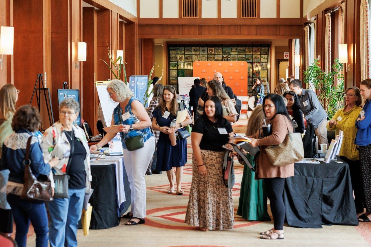 Child care professionals gather in the hall during a break in the symposium.